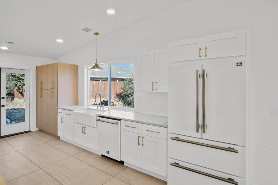 Kitchen of the Diamond Valley Craftsman with white cabinets and large sink
