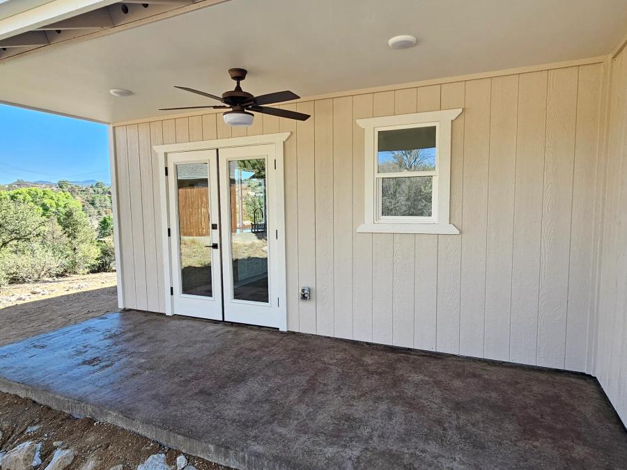Covered porch of the Diamond Valley Craftsman with doors opening to the home