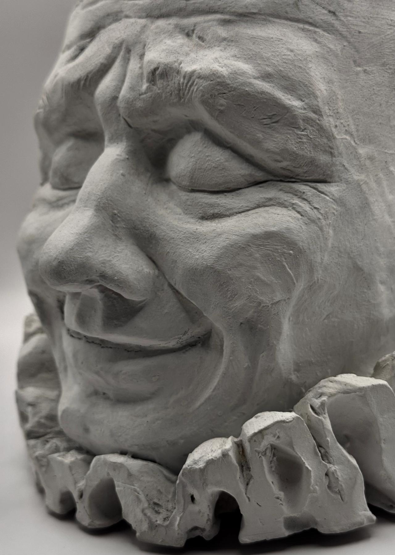 Close-up of the clay face and its ruffled collar, three-quarter view