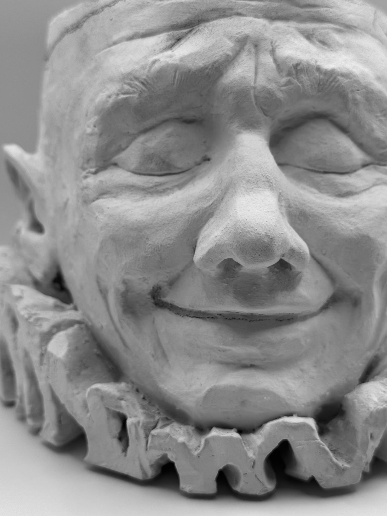 Close-up of the smiling clay face, front view