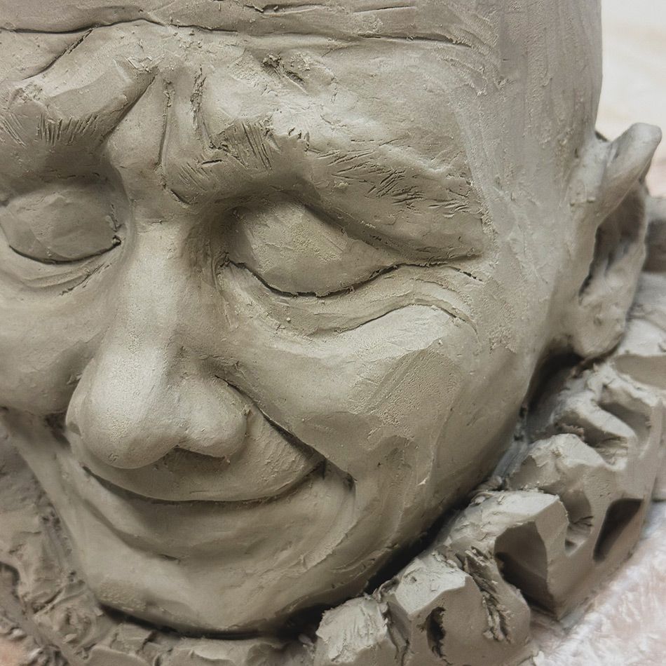 Clay sculpture of a smiling face with closed eyes