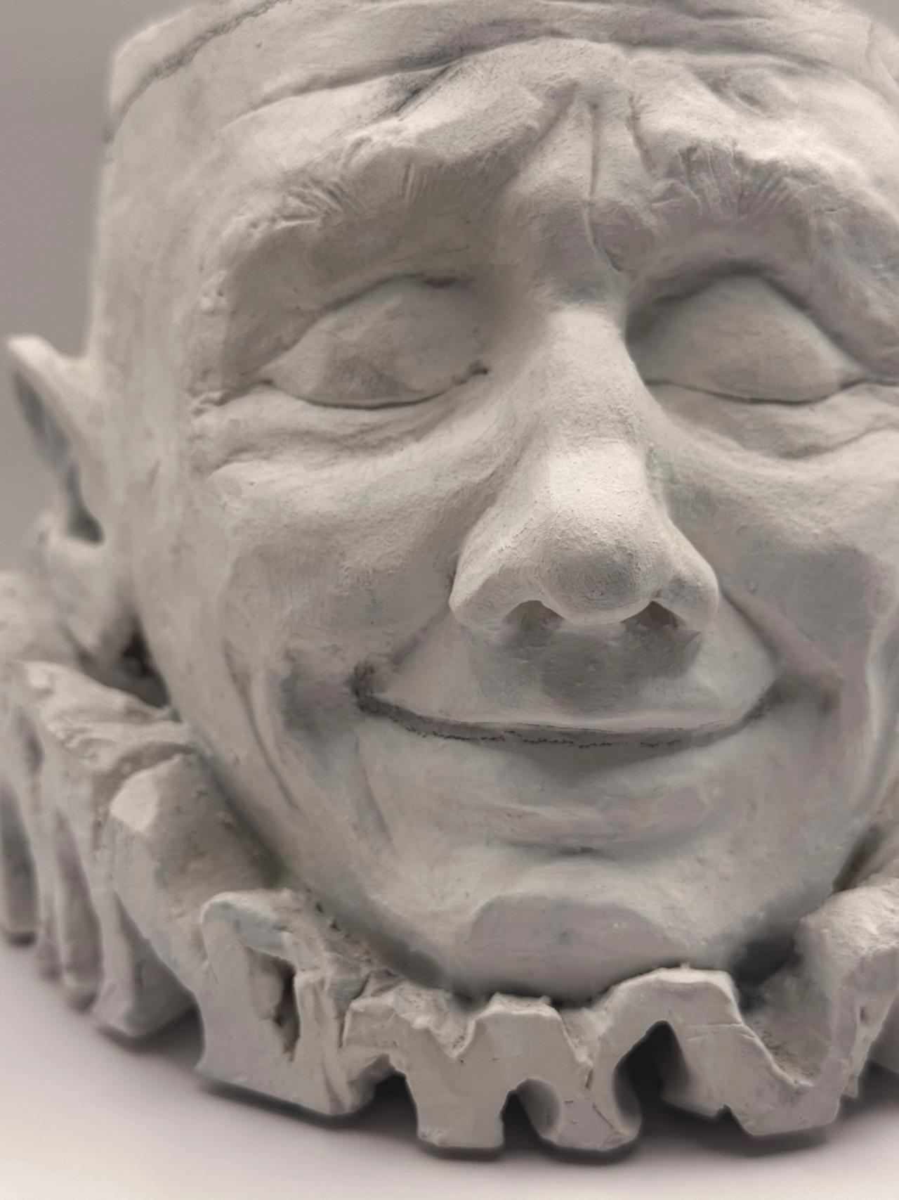 Close-up of the smiling clay face, front view