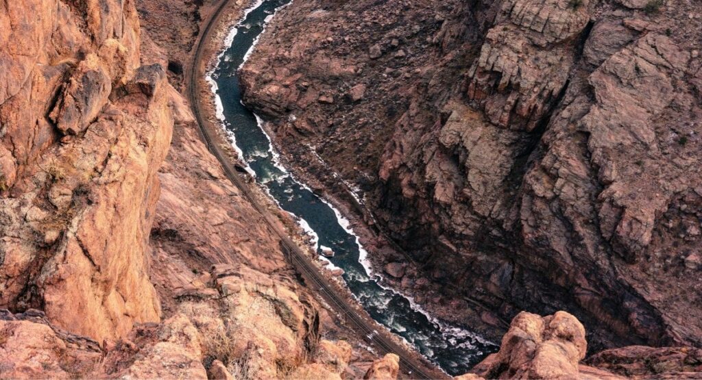 Aerial view looking straight down into Royal Gorge in Cañon City, Colorado, with the Arkansas River rushing through the red rock walls