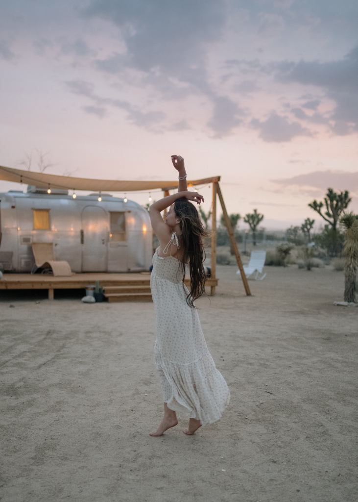 Woman in front of vintage Airstream