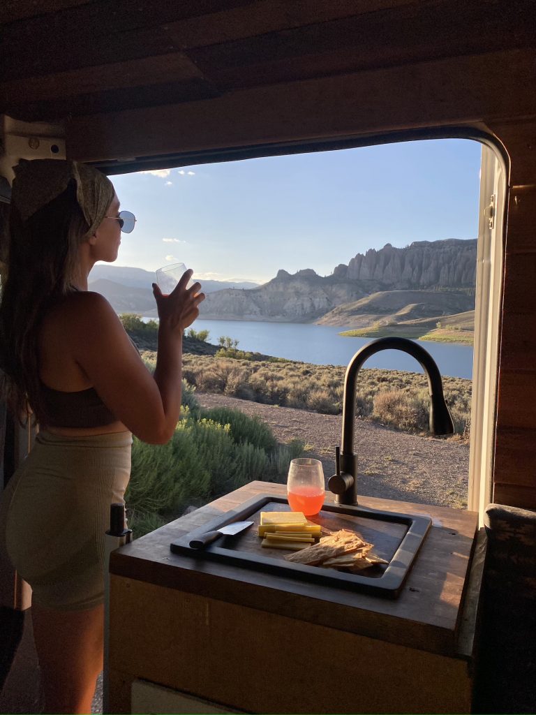 Wine, cheese, and crackers with epic campervan view.