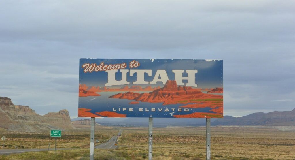 "Welcome to Utah – Life Elevated" state border sign overlooking Kane County's desert highway
