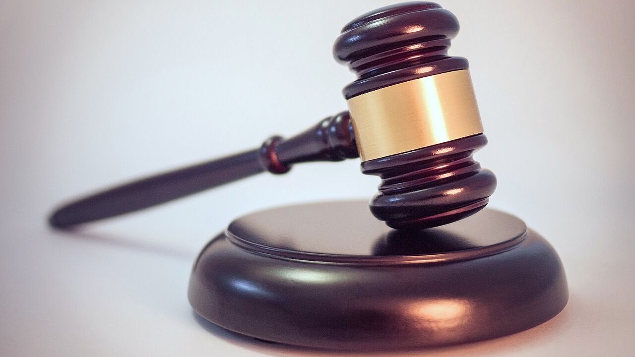 Wooden auction gavel resting on its sound block