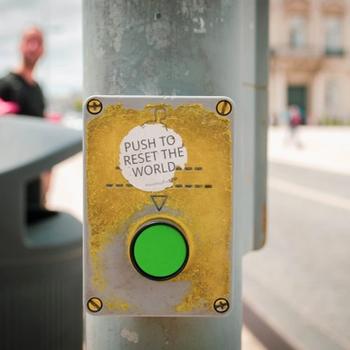 Green button with a sticker saying push to reset the world
