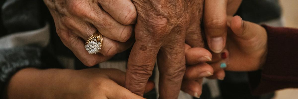 Five intertwined hands belonging to people from multiple generations