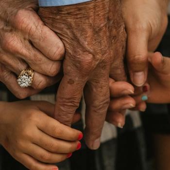Five intertwined hands belonging to people from multiple generations