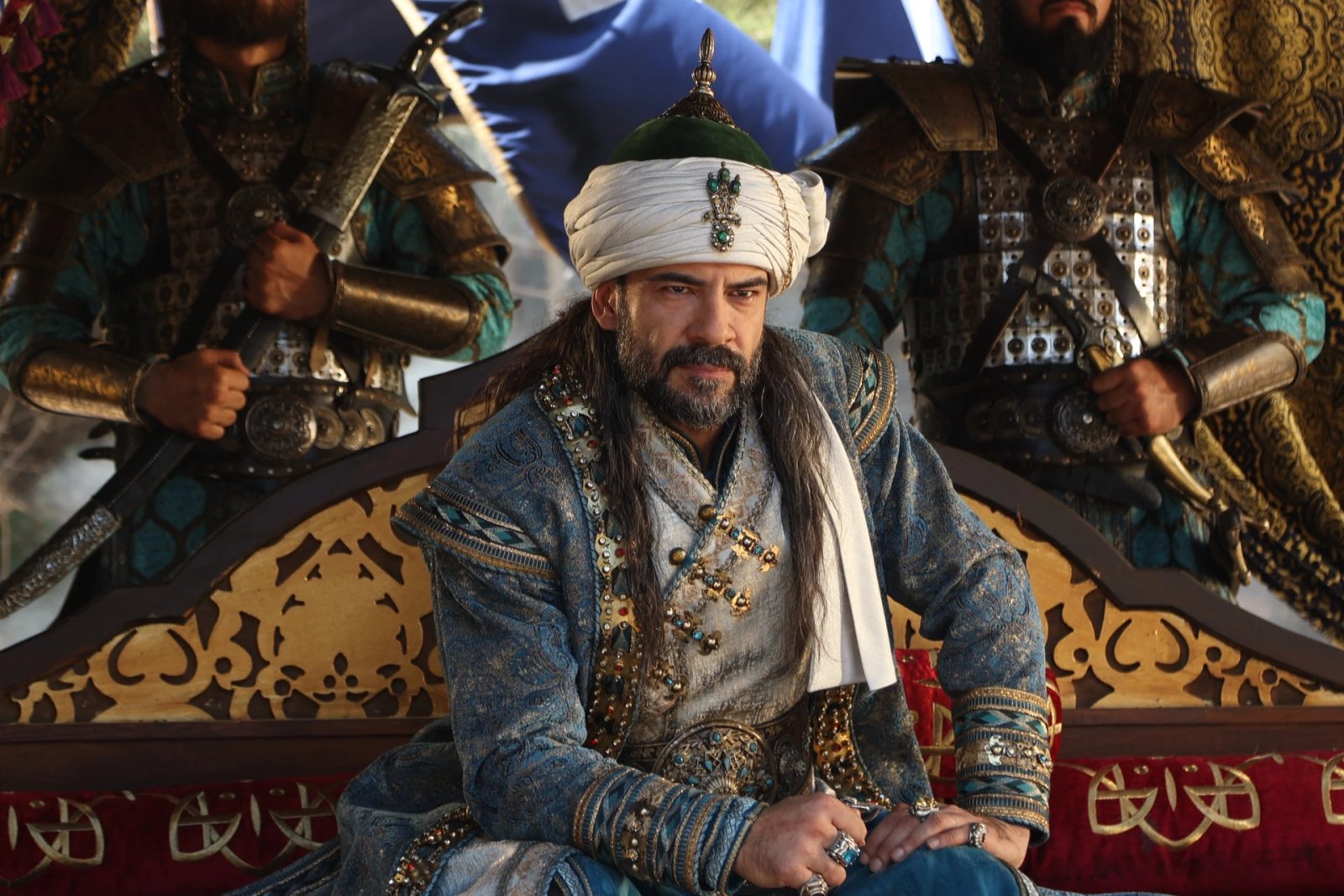 A ruler seated on his throne, flanked by his guards