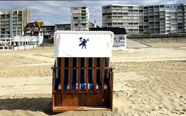 Cabine de plage traditionnelle sur le sable du Touquet-Paris-Plage, face aux immeubles de la digue