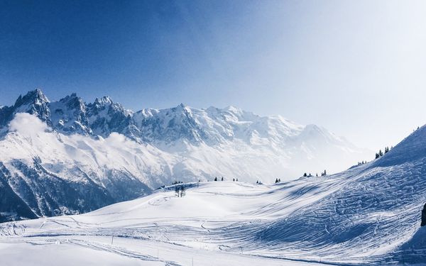 Vue sur les Aiguilles de Chamonix et le massif du Mont-Blanc depuis Planpraz, ciel bleu et sommets enneigés
