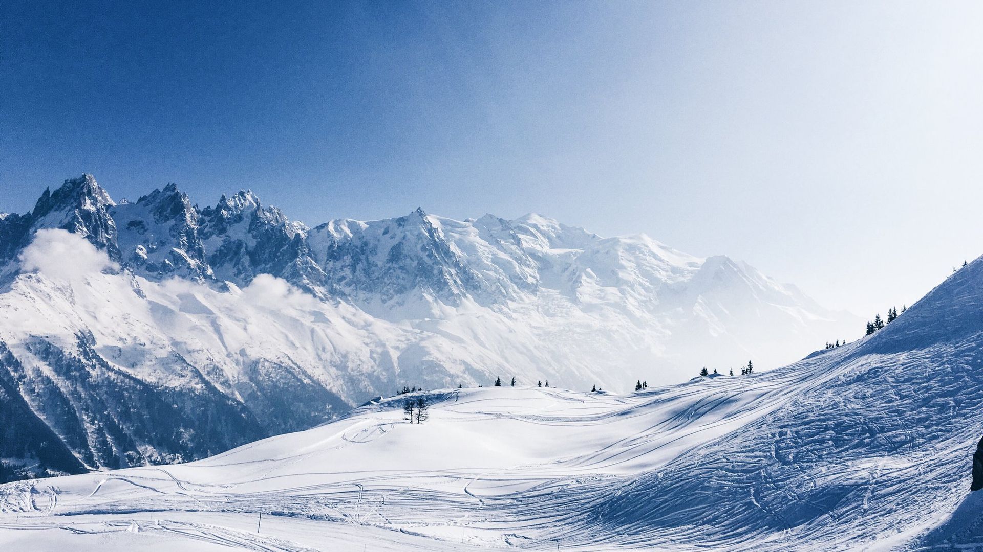 Vue sur les Aiguilles de Chamonix et le massif du Mont-Blanc depuis Planpraz, ciel bleu et sommets enneigés