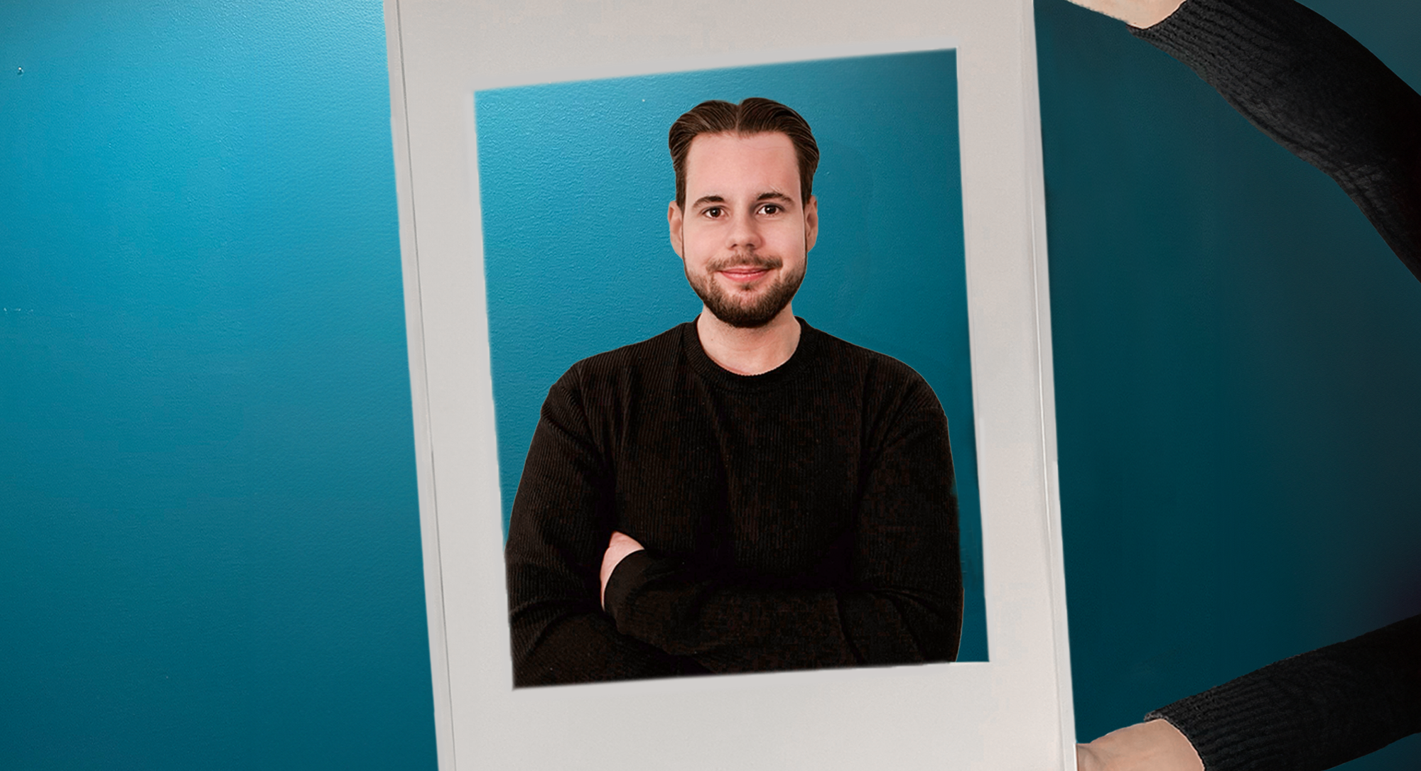 Nils som jobbar på Sappa ler mot kameran genom en vit fotoram.