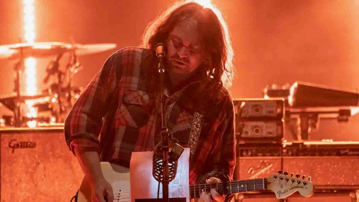 The War on Drugs perform onstage under blue and purple lights