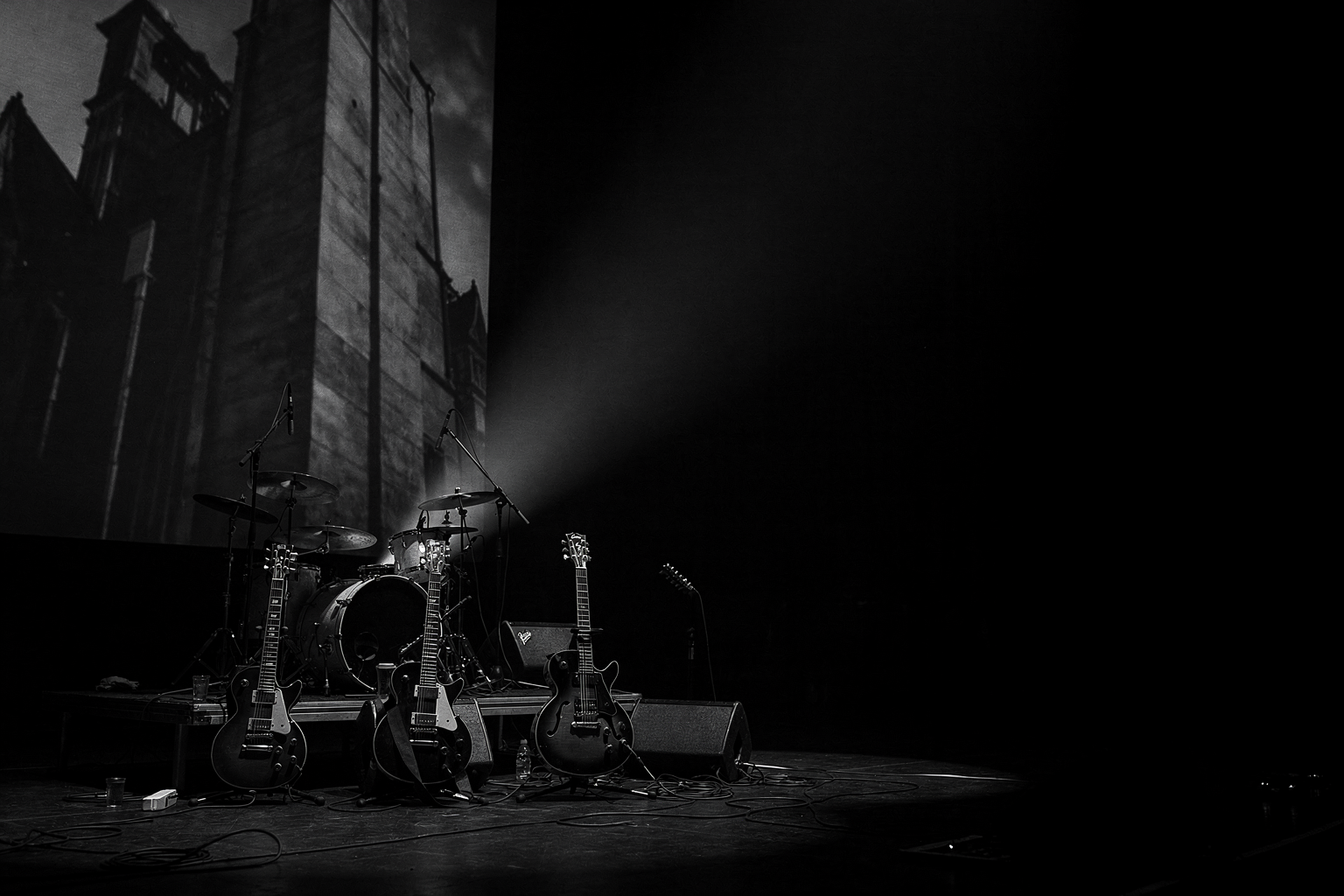 Dark stage instruments and projected light for a post-rock starter guide.