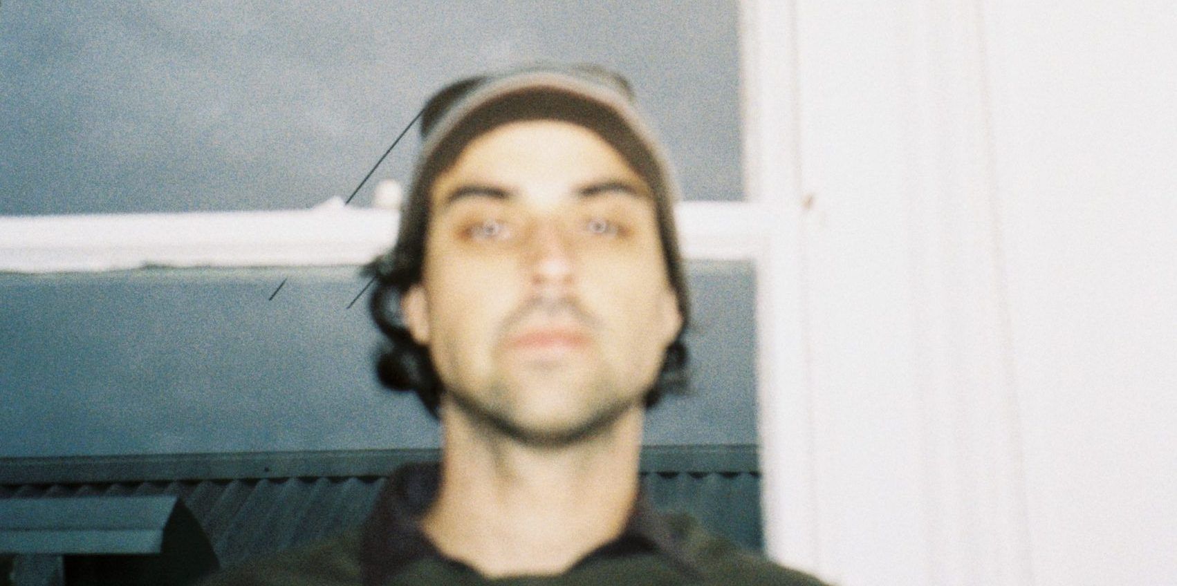 Way Dynamic's Dylan Young in a grainy close-up wearing a cap indoors