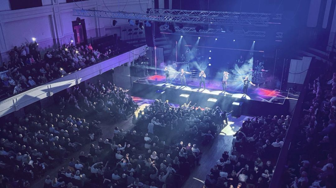 Full house town hall with live music on stage