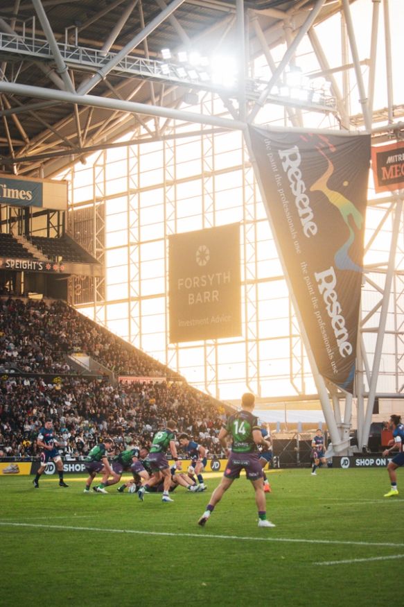 Highlanders with sponsors branding in the background