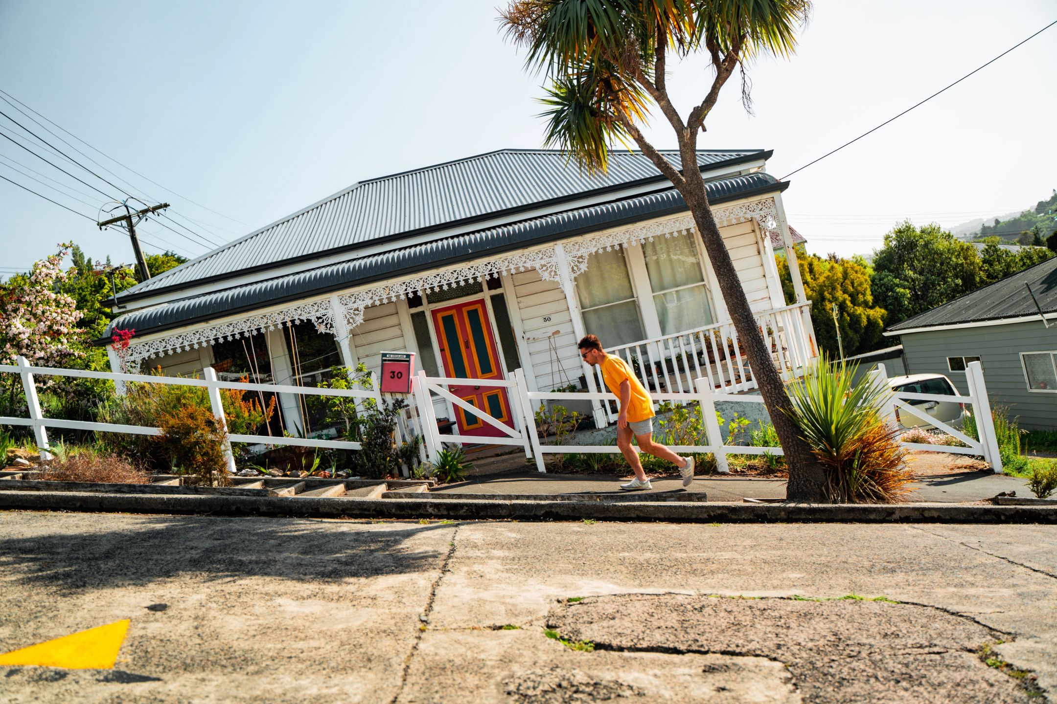 Man in a yellow t-shirt walking up Baldwin St - the steepest street in the world. Photo: Roady