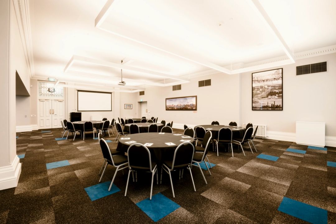 Conference Room laid out with seating around round tables.