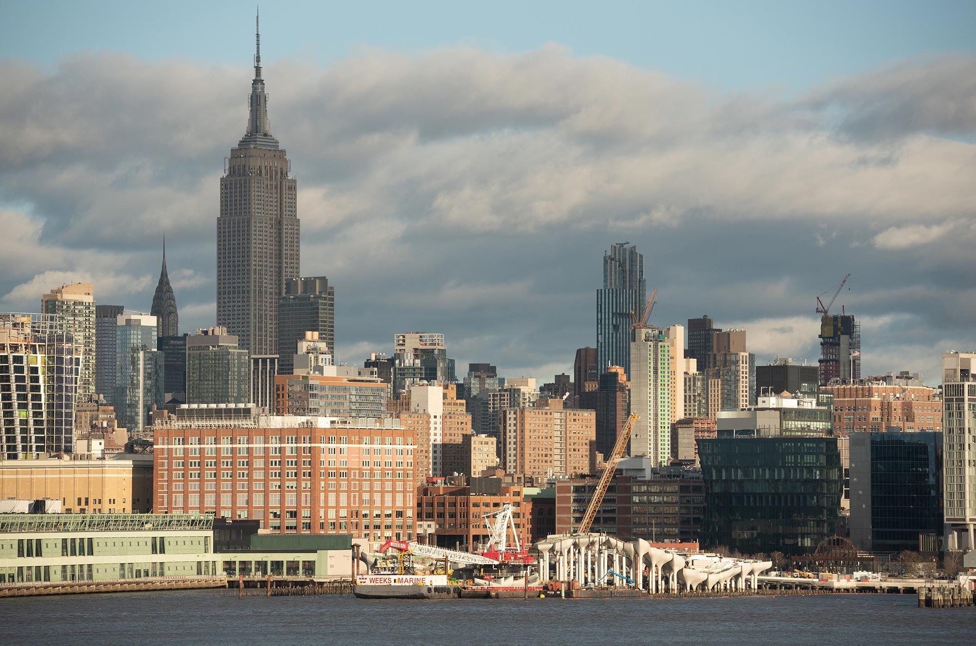 View of Little Island construction site with Manhattan skyline in the background.