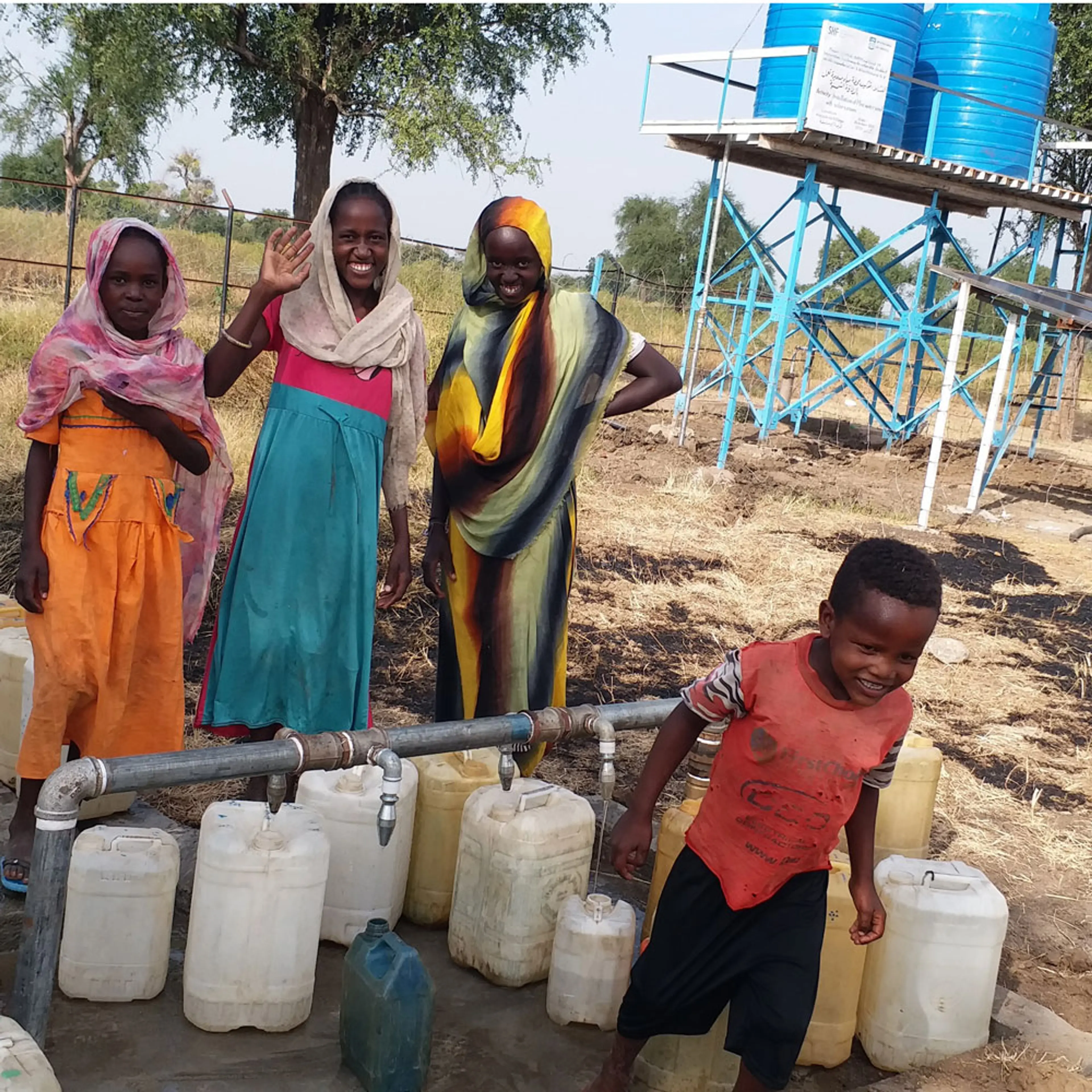 Kvinnor och barn hämtar vatten vid brunn i Sudan