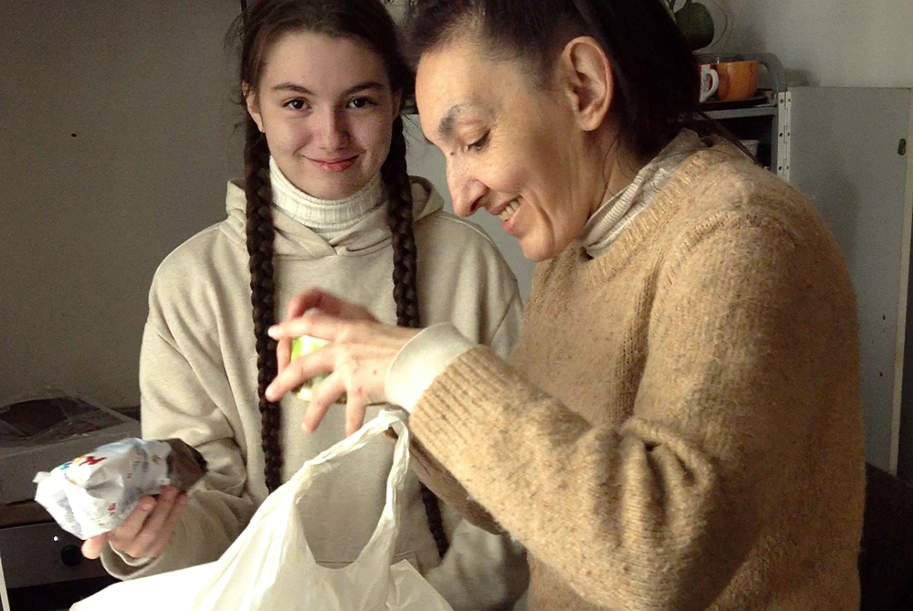 Flicka och mamma som packar upp matvaror i Ukraina