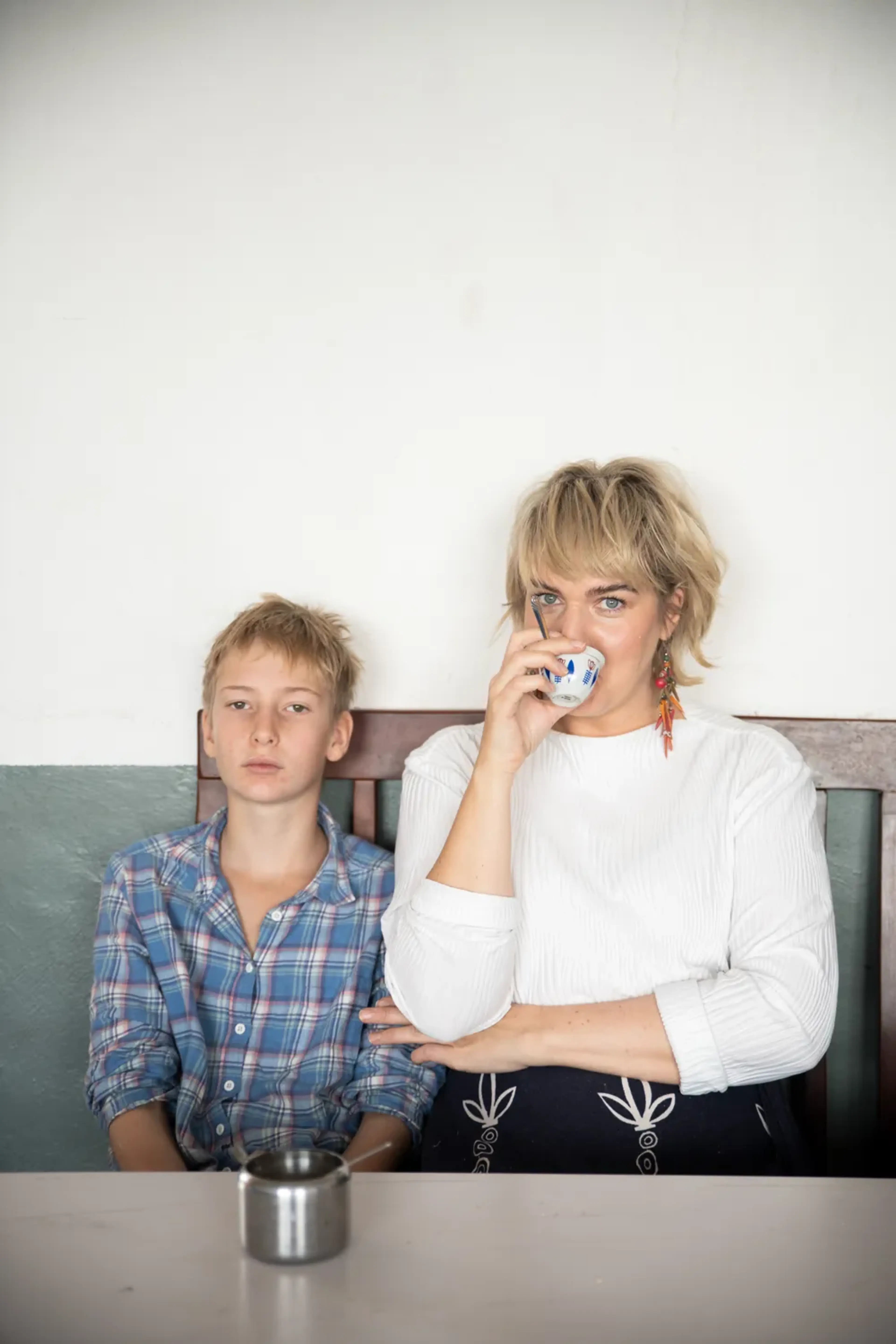 Clara och hennes son sitter vid ett bord på en skola och dricker kaffe
