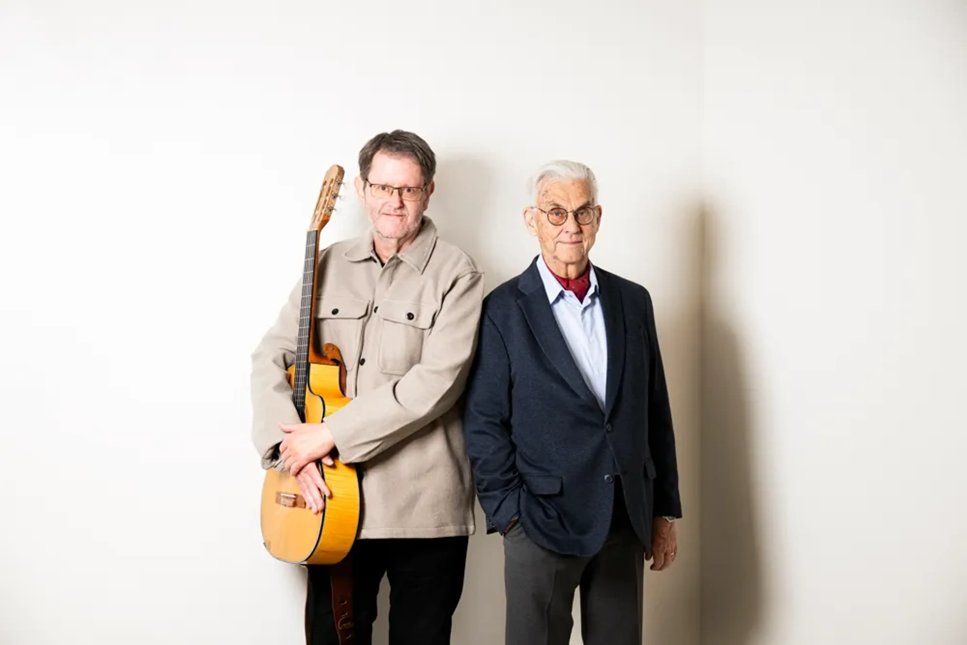 Perla Bjurenstedt och Birger Thureson står mot en vit vägg och ler mot kameran