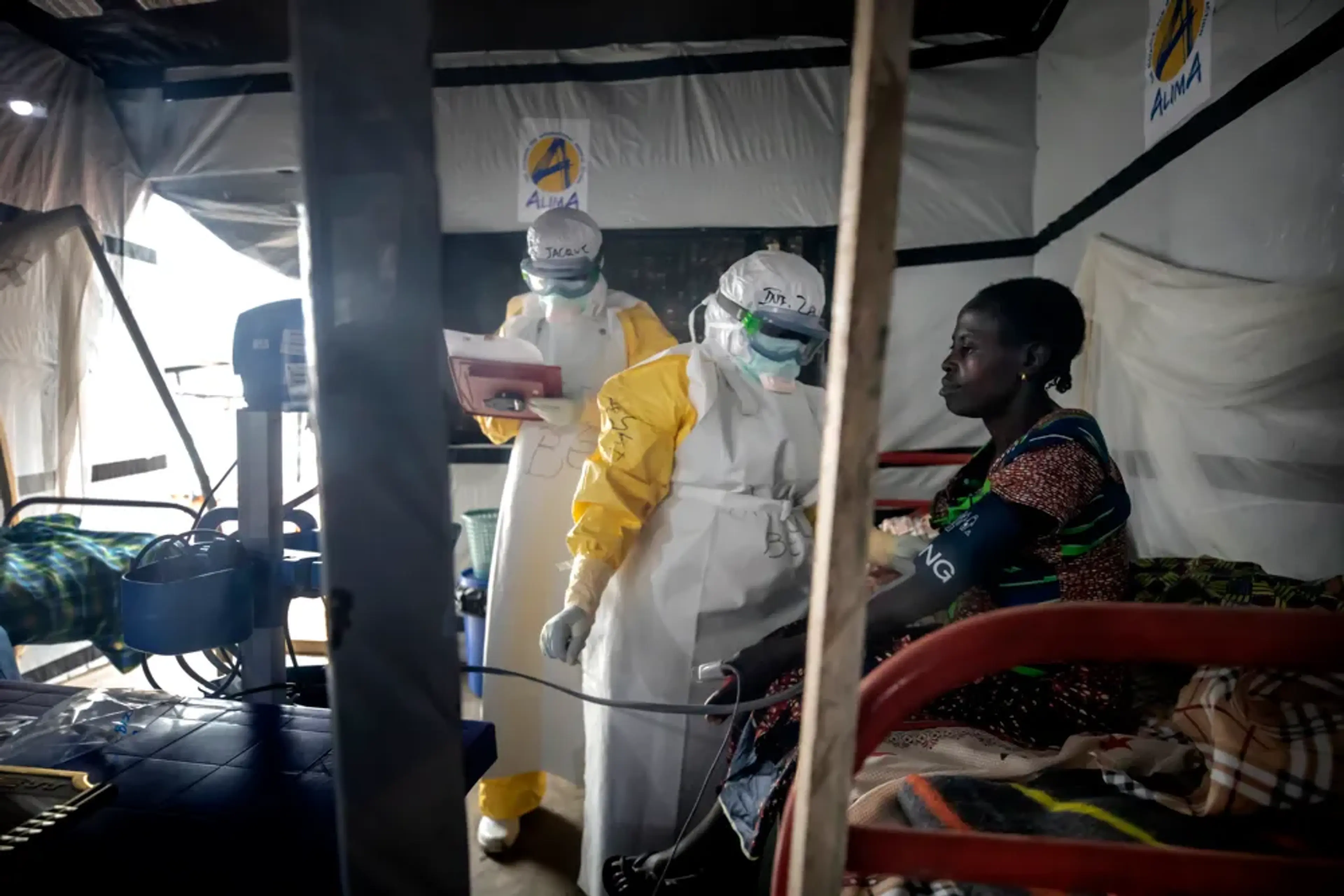 Vårdpersonal i skyddsutrustning undersöker en patient under ett ebolautbrott i DR Kongo.