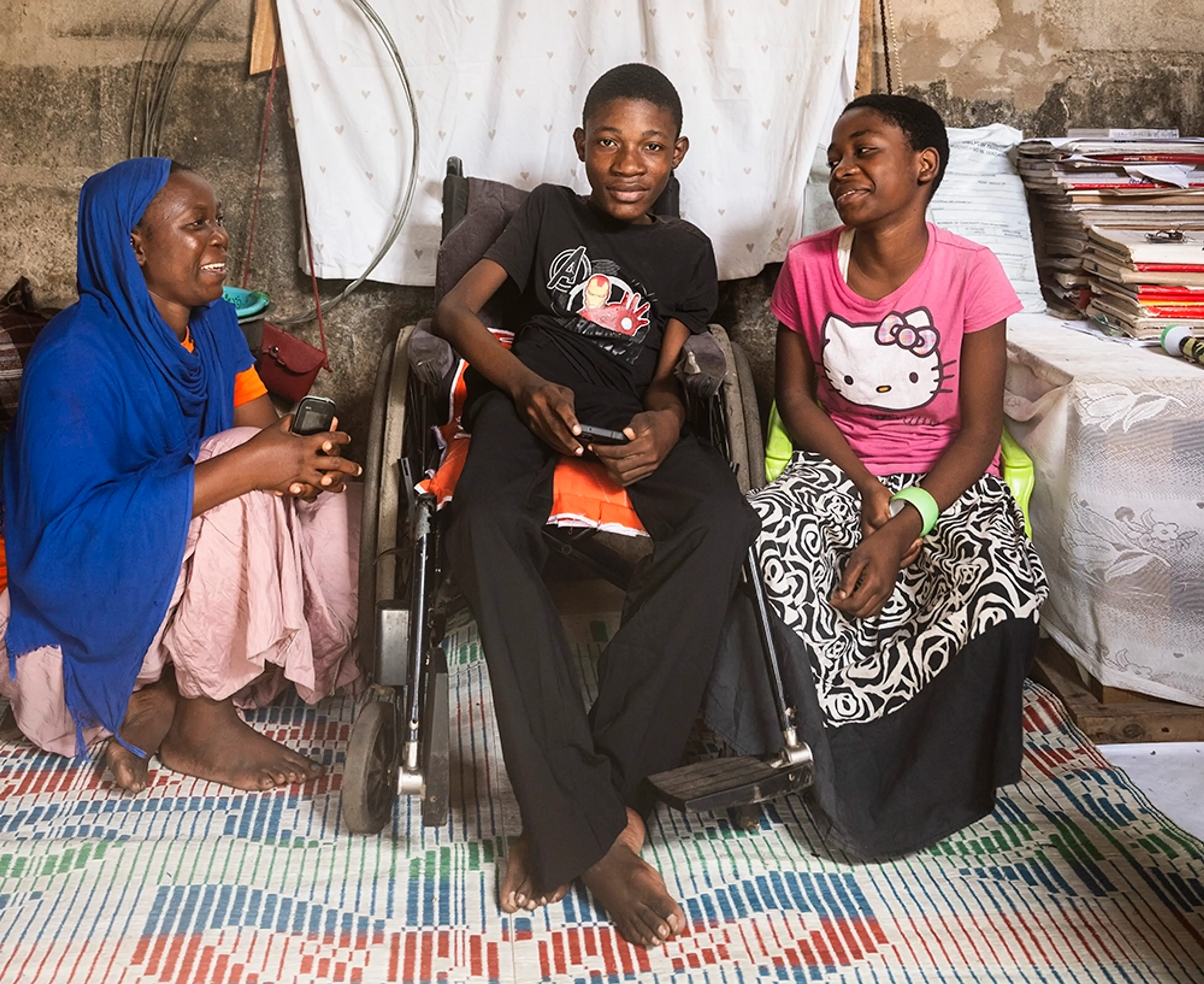 Kvinna och två barn i Tanzania, pojken i mitten är rullstolsburen