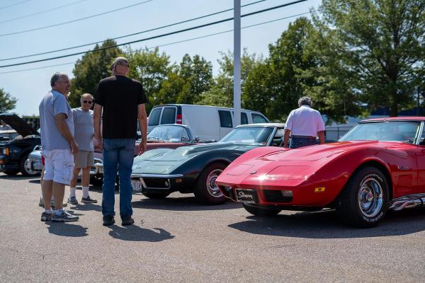 Two antique Corvettes parked next to eachother.
