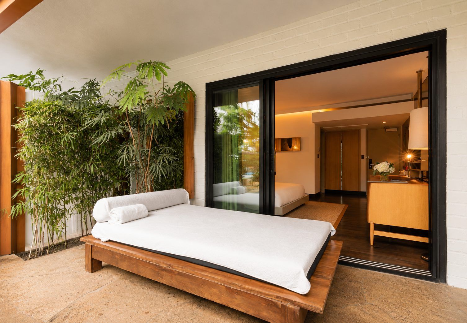 A bed on a terrace with a view of the room