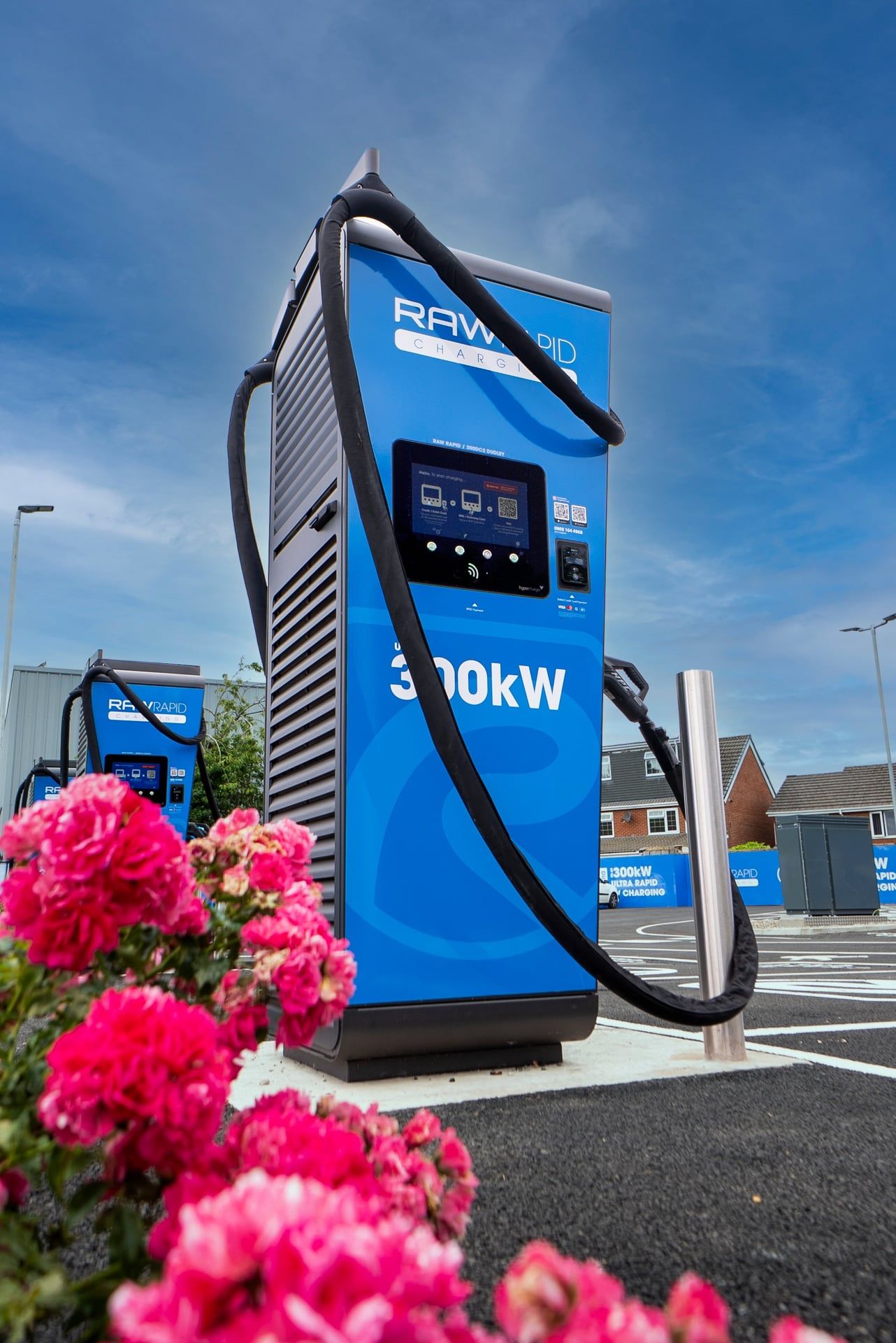 Pink flowers in front of a 300kW EV charger