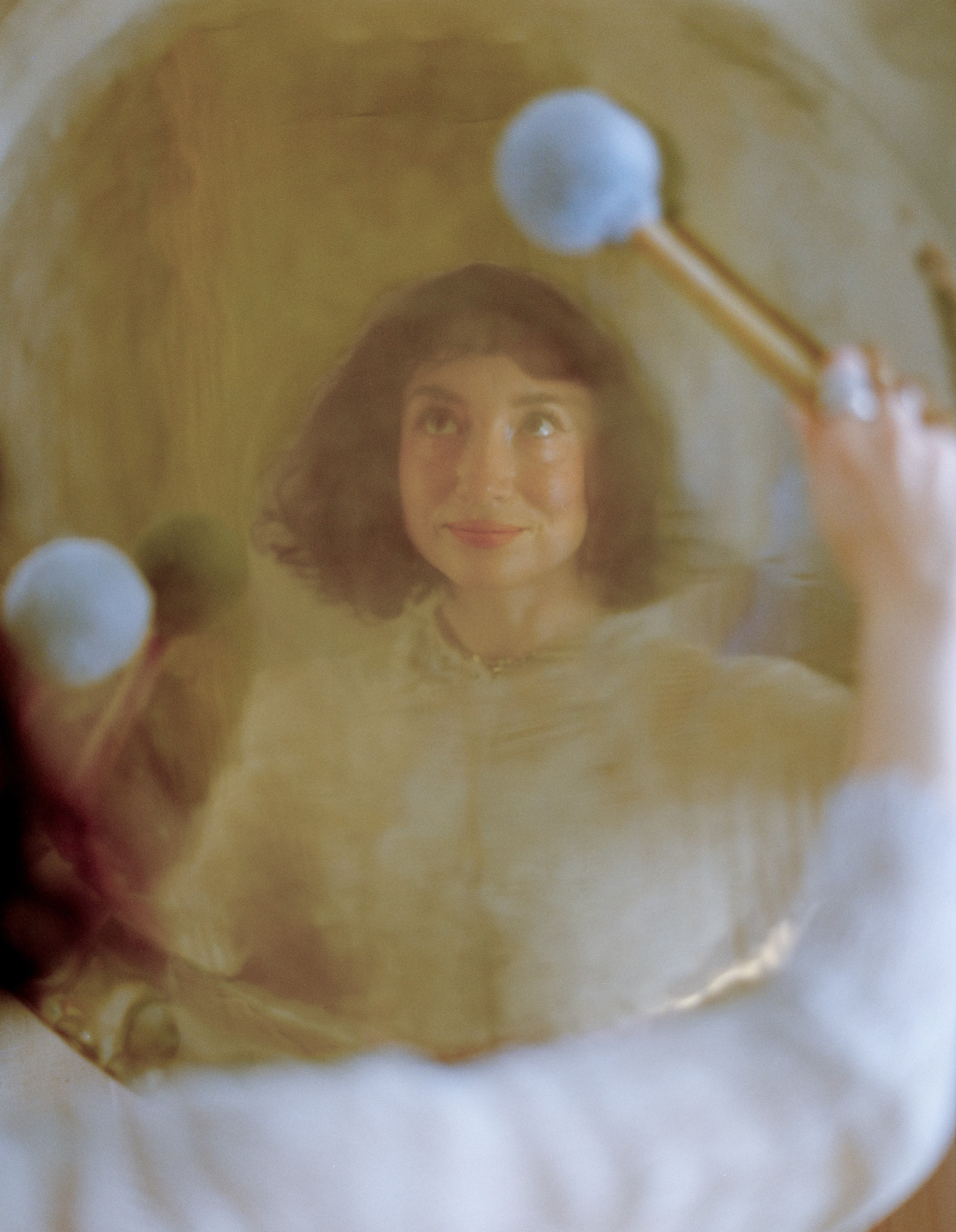 Allison Bagg's reflection seen through a large gong in her Los Angeles home, medium format film by Nathaniel Perales