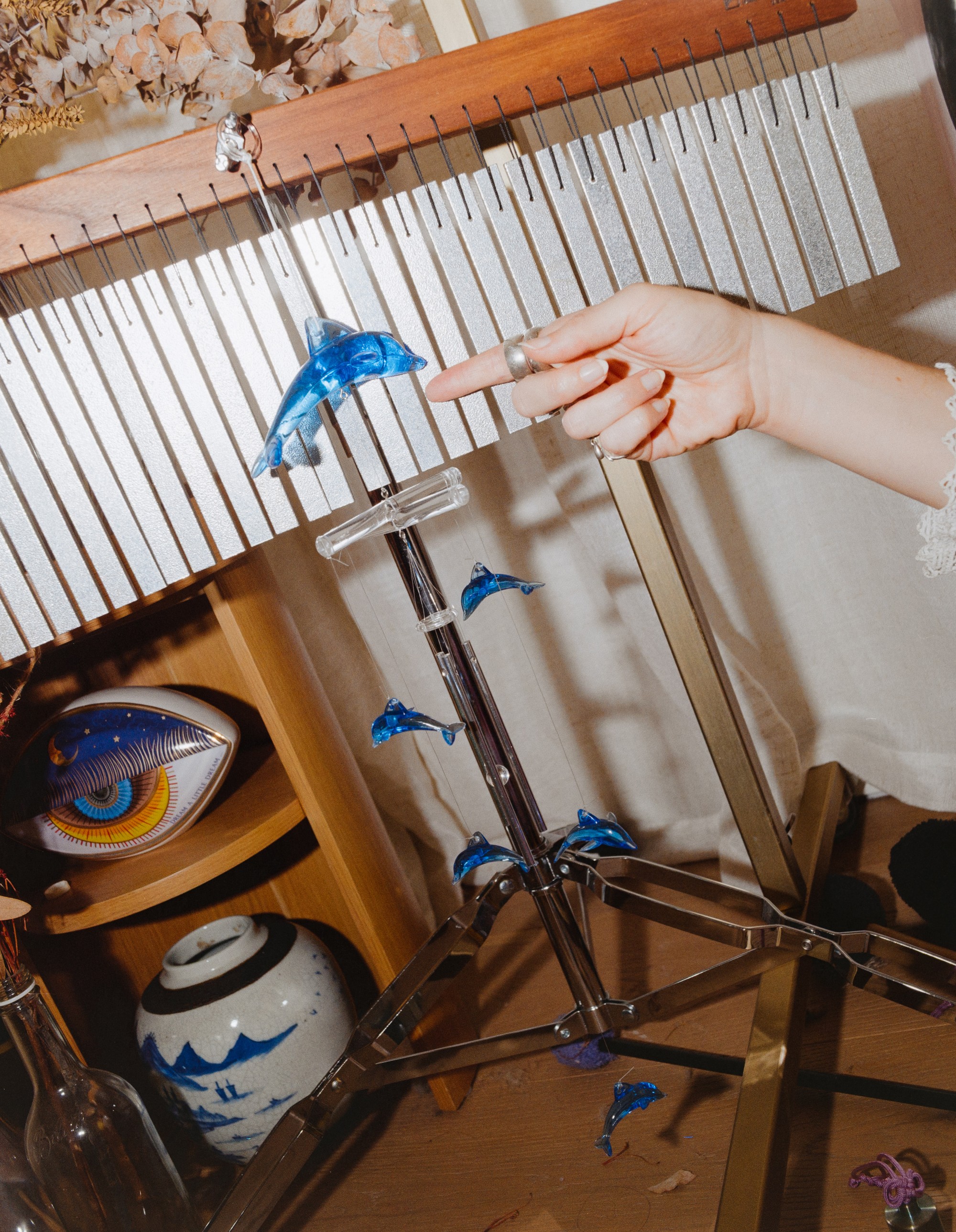 Detail of chimes and a blue dolphin figurine in Allison Bagg's Los Angeles sound healing space, medium format film by Nathaniel Perales