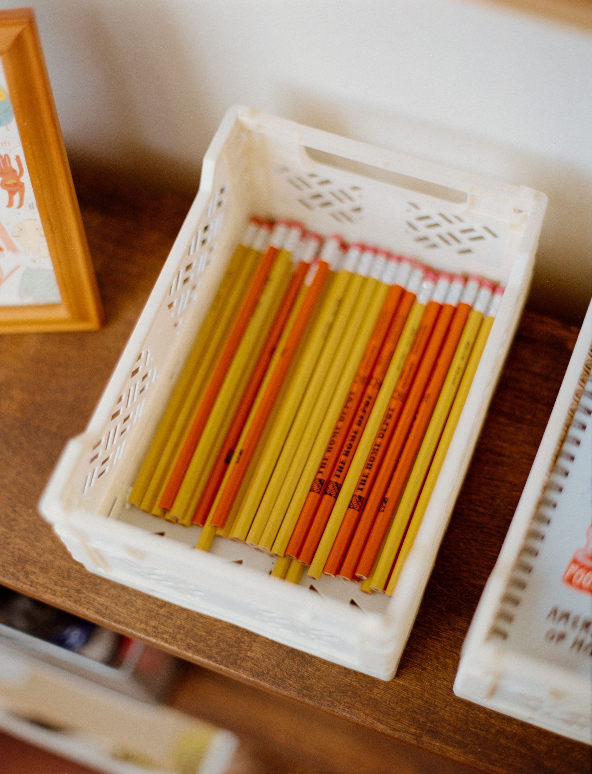 Tray of pencils on a wooden desk in Burger Babie Addeline Griswold's Los Angeles studio, shot on medium format film