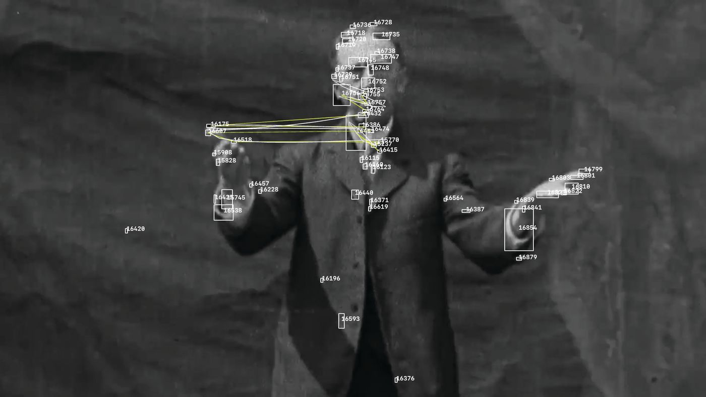 Still from Algorithmic Preservation — an archival figure signing, overlaid with machine-vision tracking boxes and connecting lines