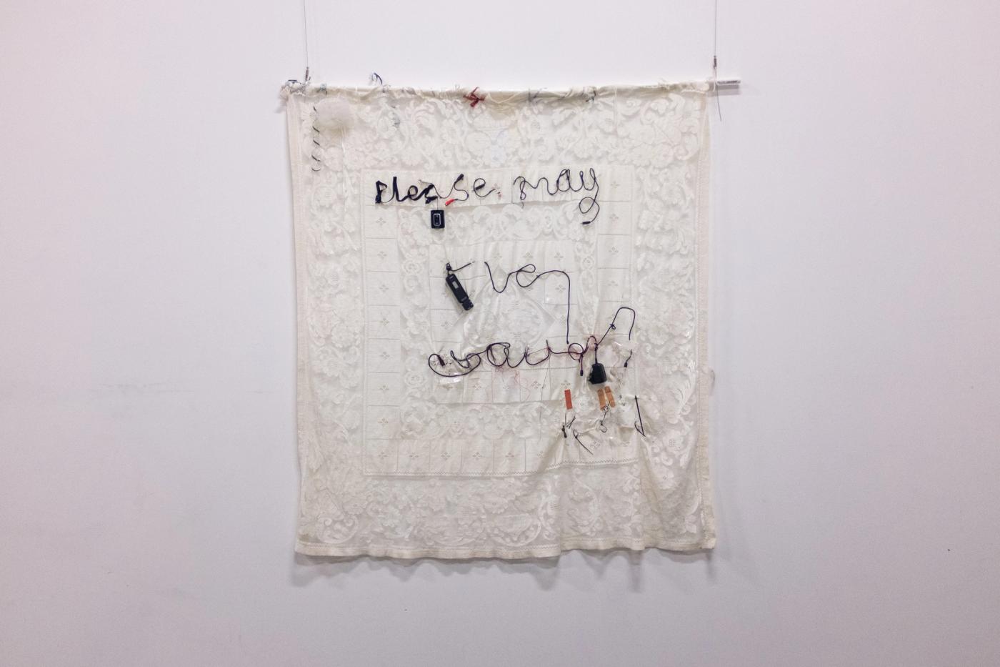 Please, may I be excused? — lace tablecloth with text embroidered in hearing-aid wires and assistive tech