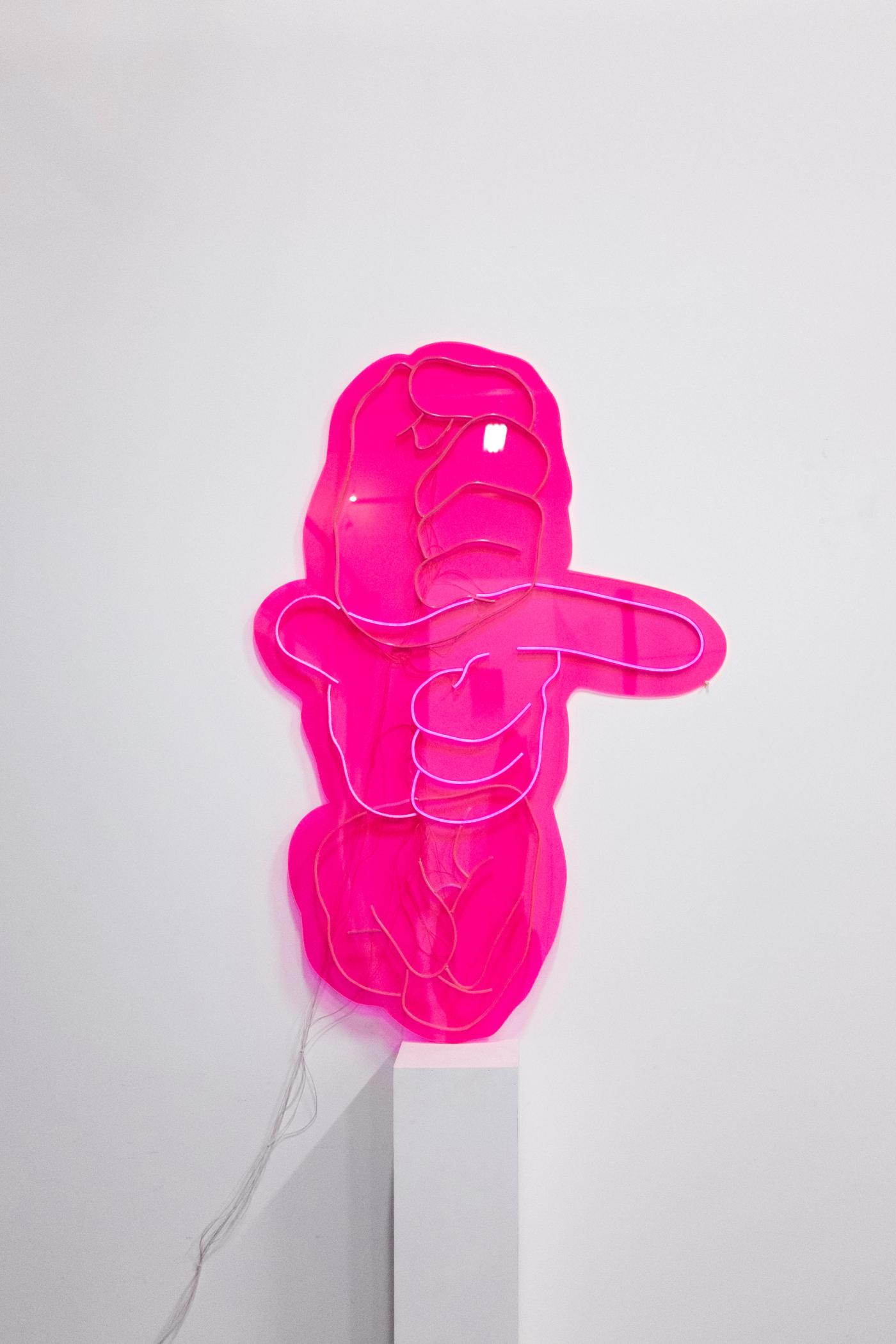UNTITLED SIGN — hot-pink acrylic handshape lit by neon LED, mounted on a plinth
