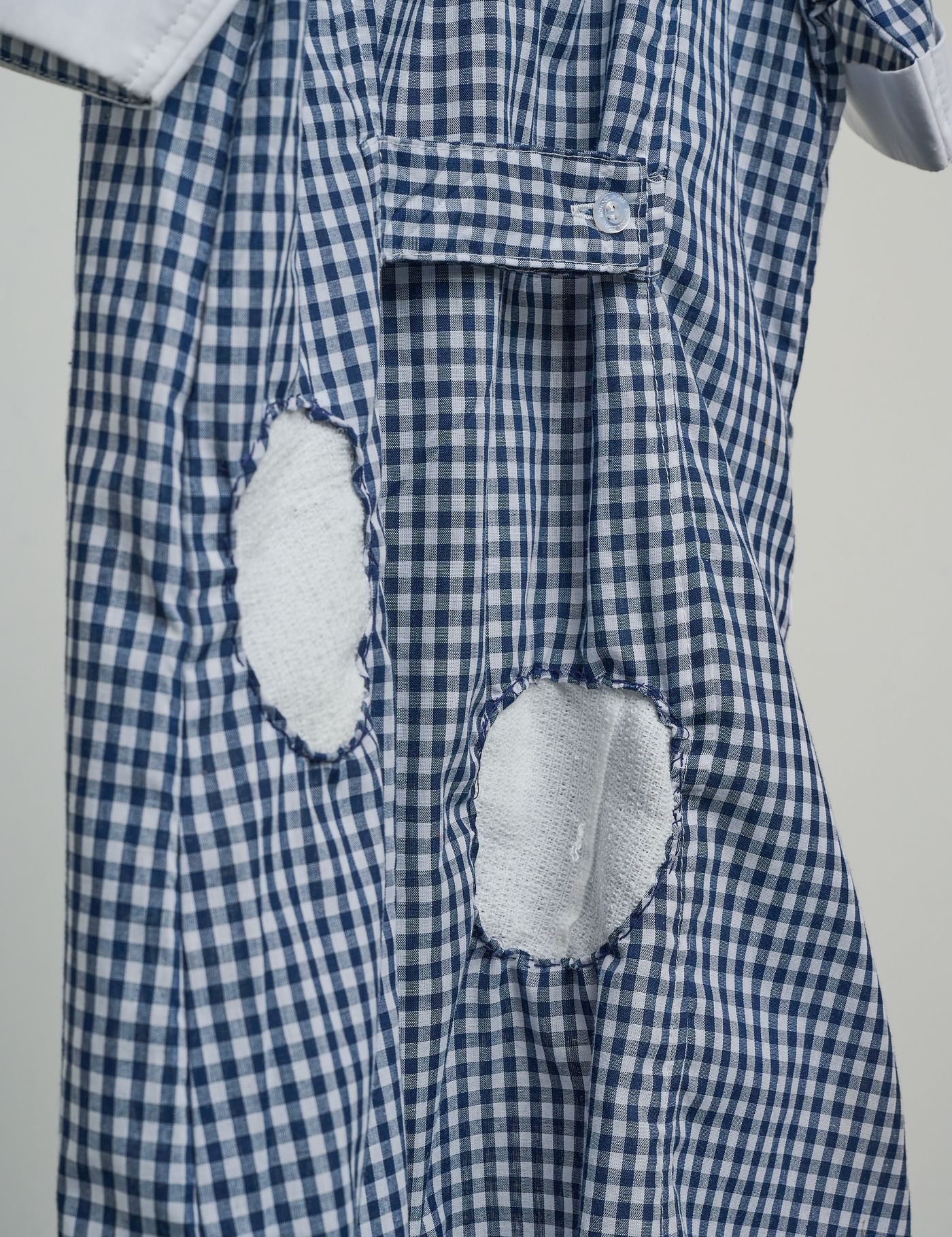 Detail — cut-out holes in the back of the dress, covered with bandage patches