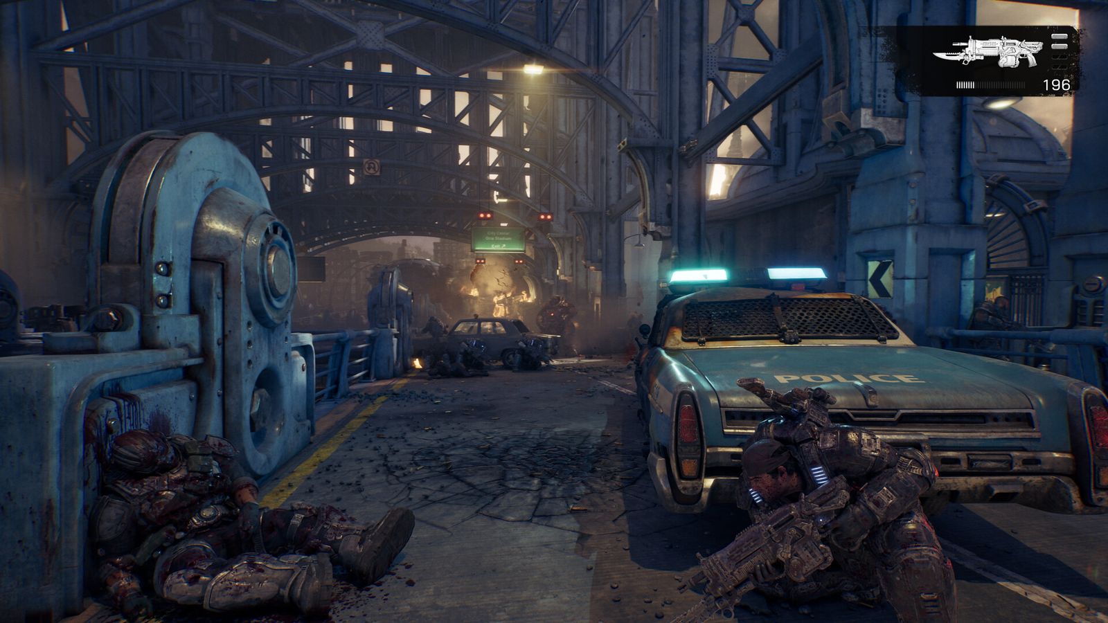 A COG soldier takes cover behind a police car on a ruined city street under a steel bridge in Gears of War: E-Day