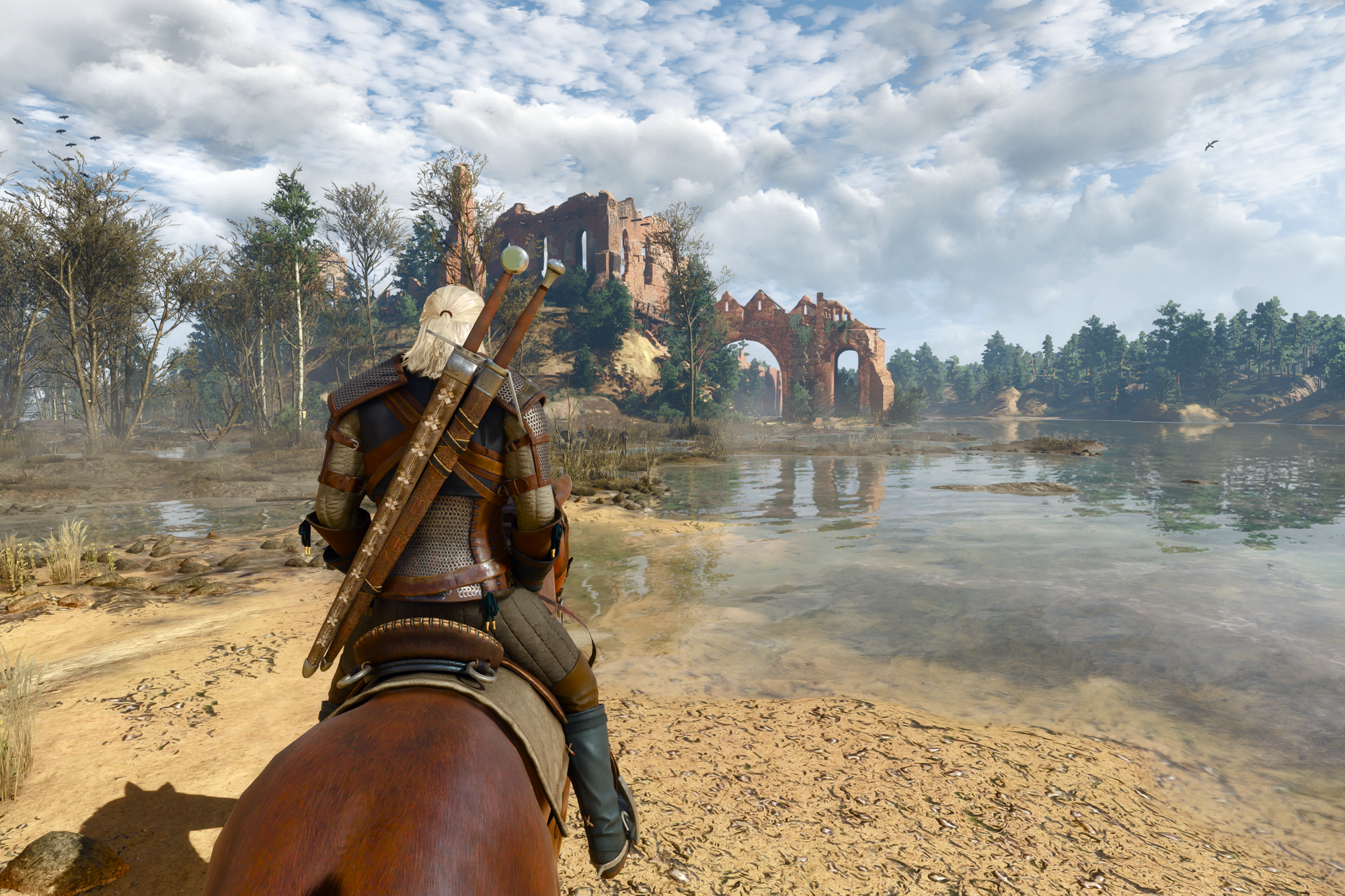 Geralt riding his horse Roach along a sandy lake shore towards stone ruins