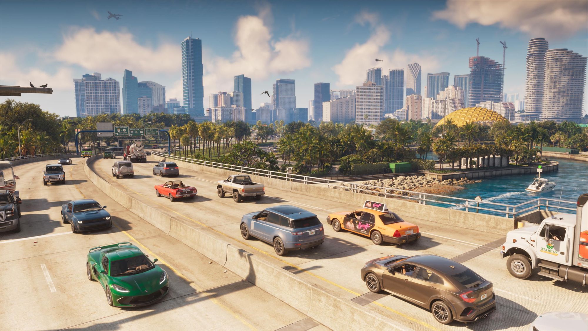 Cars and a taxi on a sunny Vice City highway with palm trees, the sea and a skyline of towers behind