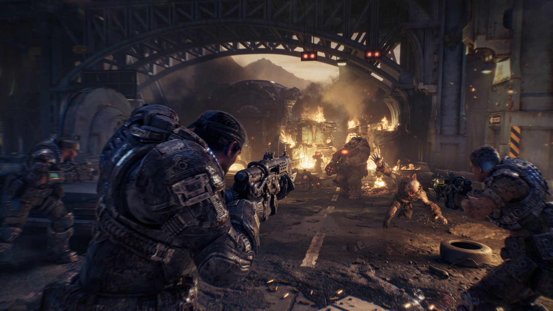 Armoured COG soldiers crouch and fire rifles down a burning city street beneath a steel bridge