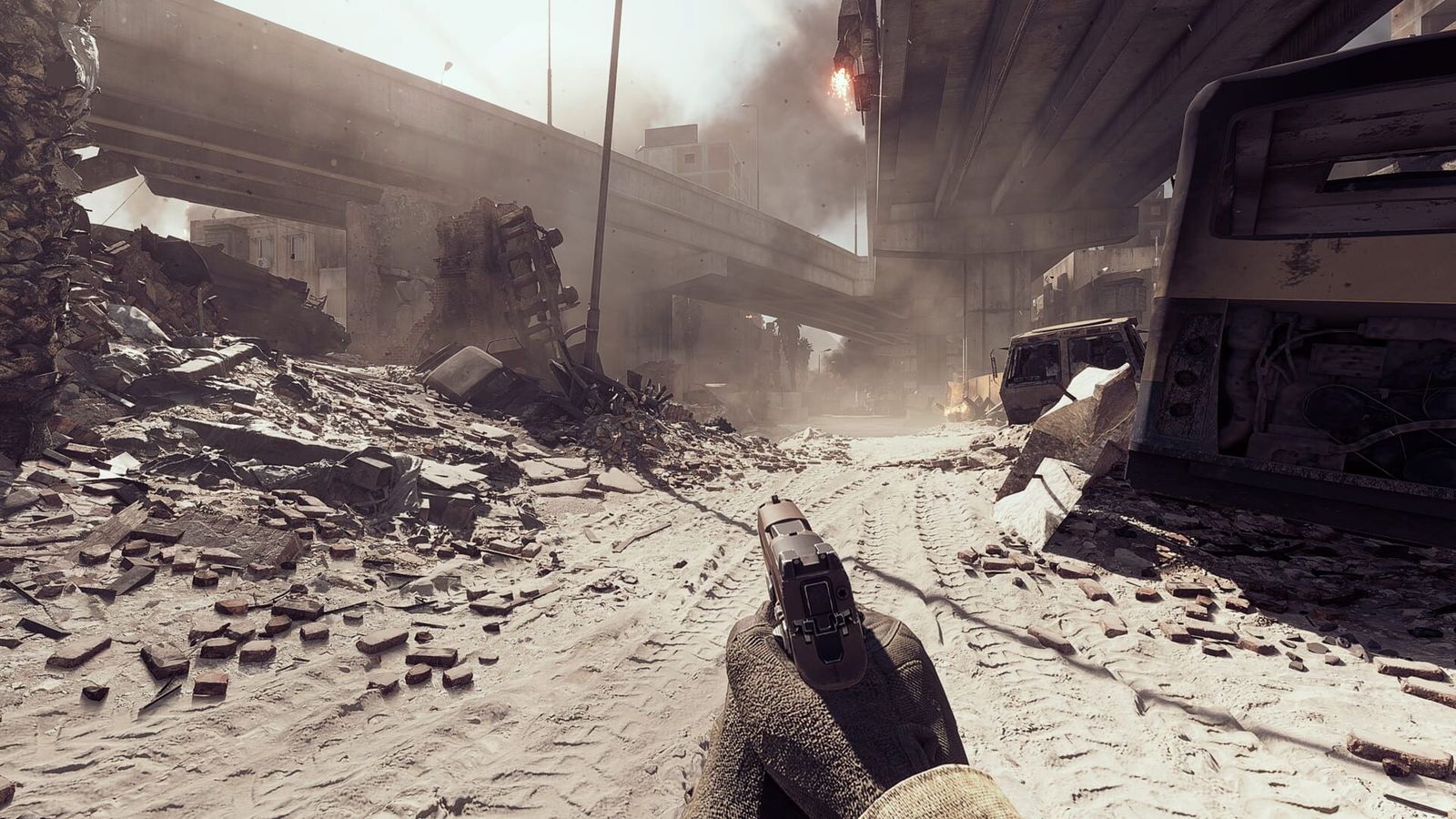 First-person view of a soldier holding a pistol under a concrete overpass littered with rubble and smoke