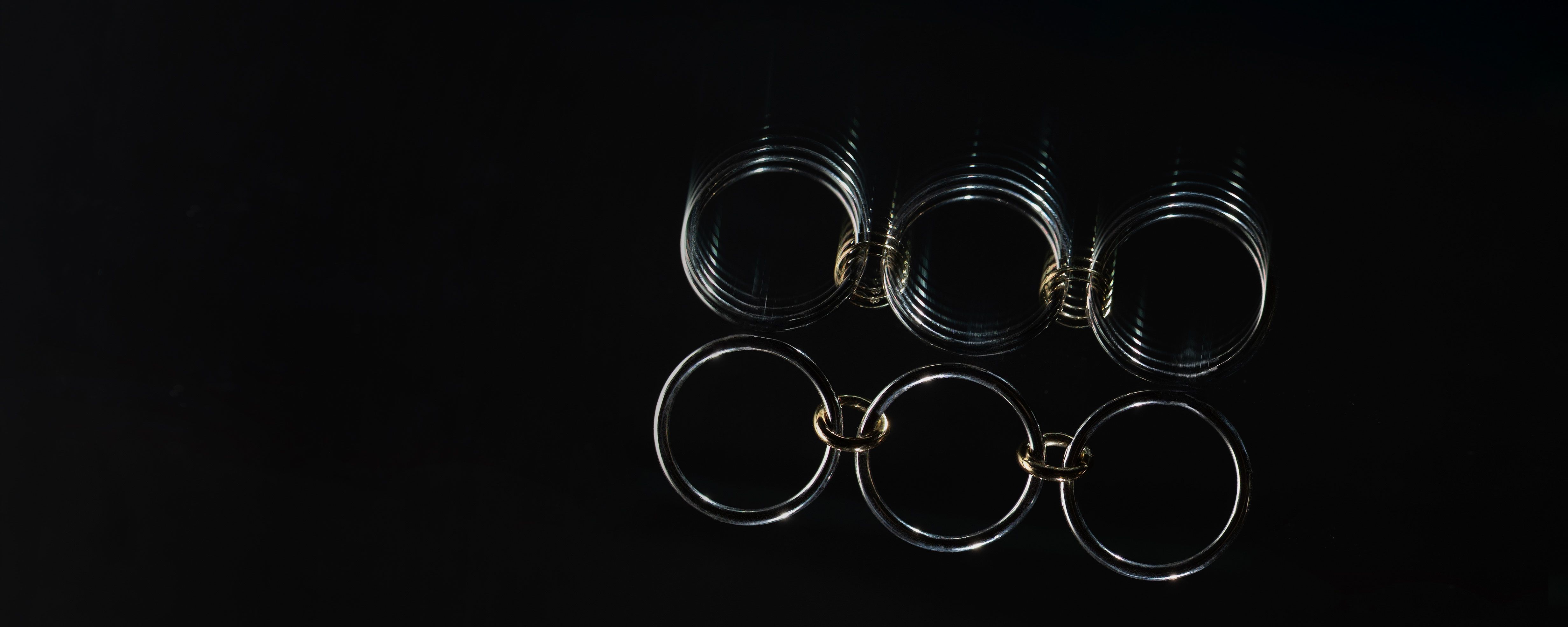 Spinelli Kilcollin Solarium SG linked ring made of sterling silver and 18 karat yellow gold floating on black background