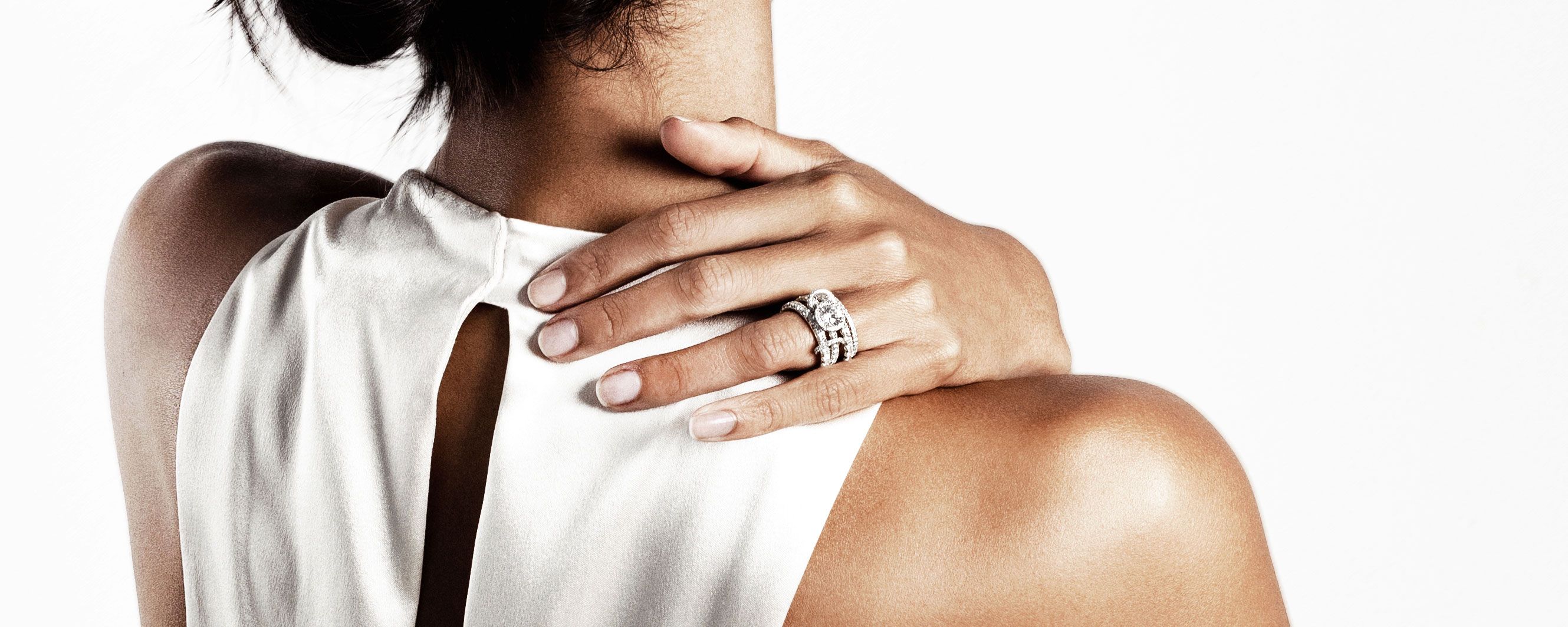 Spinelli Kilcollin image of mother and child's hands against white garment featuring linked rings stacked and spread across fingers, wearing single band, Polaris Blanc and Vela SG Shop in Stock for Mother's Day Luxury Jewelry made to order 